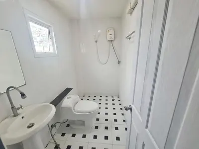 a white bathroom with a toilet and a sink at El Huq in Bangkok