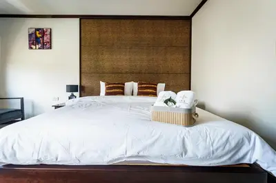 a bedroom with a white bed with two towels on it at Lux Boutique Hotel in Nonthaburi