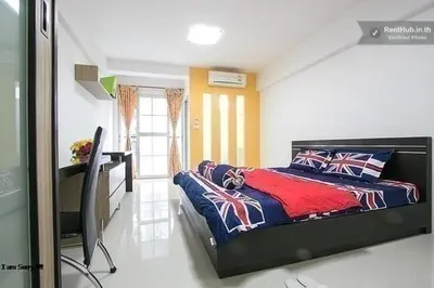 a bedroom with a bed and a desk in it at THE PRIZE in Ban Yang