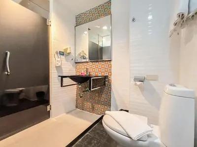 a bathroom with a toilet and a mirror at Citin Sukhumvit 11 Nana Bangkok by Compass Hospitality in Bangkok
