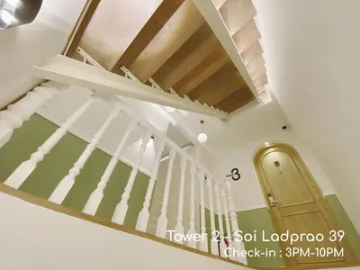 a staircase in a house with wooden ceilings at Double Bed Hotel in Bangkok