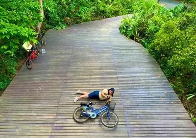 a man laying on a bike on a bridge at BaanSuanklaiKlungBangkrachao บ้านสวนใกล้กรุงบางกะเจ้า in Phra Pradaeng