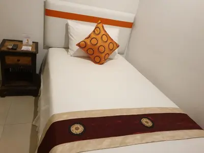 a white bed with a pillow on top of it at Arawana Residence Phromphong in Bangkok