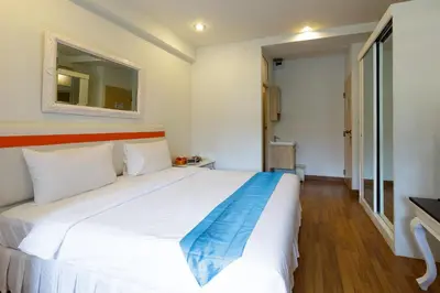 a large white bed in a room with a mirror at Arawana Residence Phromphong in Bangkok