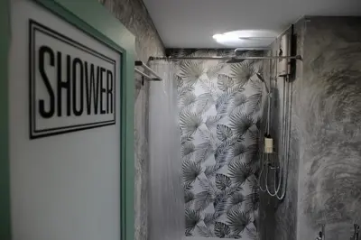 a shower in a bathroom with a shower curtain at Baan Khun Pra Duplex Rm3 Bangkok in Bangkok