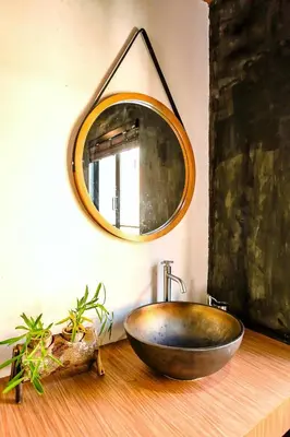 a bathroom with a copper sink and a mirror at Hidden Habitat - Design Guesthouse in Bangkok