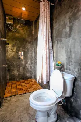a bathroom with a white toilet in a room at Hidden Habitat - Design Guesthouse in Bangkok