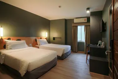 a hotel room with two beds and a window at MyBed Ratchada in Bangkok