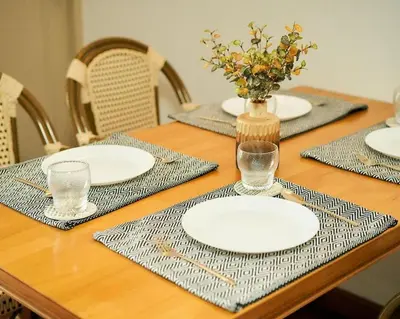 a wooden table with plates and glasses on it at Bellevue Boutique Bangkok in Amphoe Phra Khanong