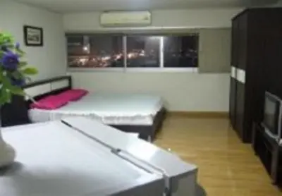a room with two beds and a couch in it at Impact Don Mueang Bangkok Guest House in Thung Si Kan