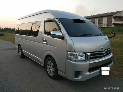 a silver van is parked on a road at Impact Don Mueang Bangkok Guest House in Thung Si Kan