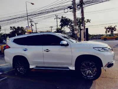 a white suv parked in a parking lot at Thailand Taxiapartment Hostel in Thung Si Kan