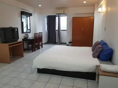 a bedroom with a bed and a table and a tv at โรงแรมวินบางนา Win Bangna Hotel in Bangna