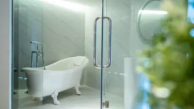 a white bath tub in a bathroom with a glass door at Pannarai Hotel Bangkok-Pra tunam in Bangkok
