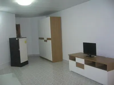 a room with a refrigerator and a table with a television at Asia Don Mueang Bangkok Condominium in Thung Si Kan
