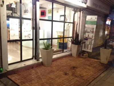 a store front with potted plants in front of a window at Bangkok Hub Hostel in Bangkok