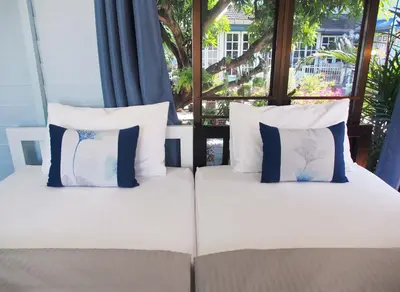 a bed with four pillows on it with a window at KINN Stay50 Bangkok in Bangkok Yai