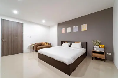 a bedroom with a large bed and a couch at My space69 in Ban Pak Khlong Khwang