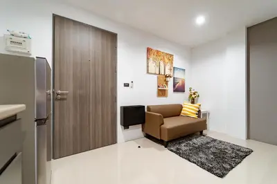a small living room with a chair and a refrigerator at My space69 in Ban Pak Khlong Khwang