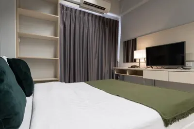 a hotel room with a bed and a flat screen tv at LKN RESIDENCE in Pom Prap