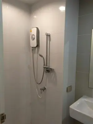 a bathroom with a shower with a soap dispenser on the wall at LKN RESIDENCE in Pom Prap