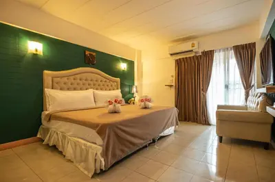 a bedroom with a bed with a green wall at I-Inn Hotel in Bangkok