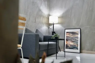 a living room with a blue couch and a mirror at The View Residence in Bangkok
