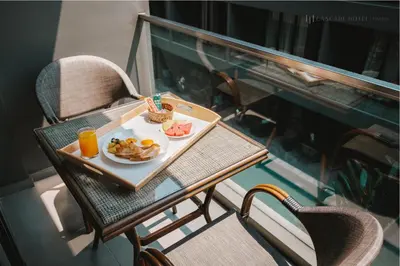 a table with a plate of food and orange juice at Cascade Hotel Bangkok in Bangkok