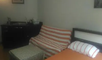 a bedroom with a bed and a dresser and a bench at Thailand Taxi Apartment Hostel in Thung Si Kan