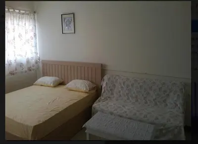 two beds in a small room with a window at Thailand Taxi Apartment Hostel in Thung Si Kan
