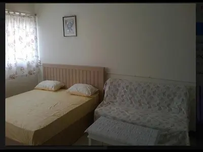 two beds in a small room with a window at Thailand Taxiapartment Hostel in Thung Si Kan
