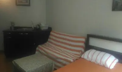 a bedroom with a bed and a dresser and a couch at Impact Challenger Muang Thong Thani Apartment in Thung Si Kan