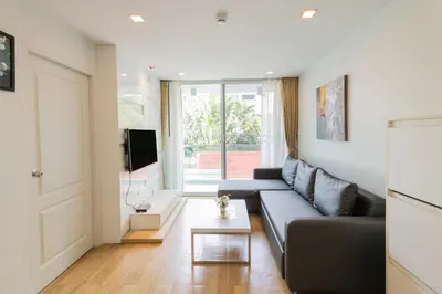 a living room with a couch and a tv at United Residence Ekamai Bangkok in Bangkok