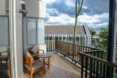 a balcony with a chair and a table at W1Bangkoknoi Hotel in Nonthaburi
