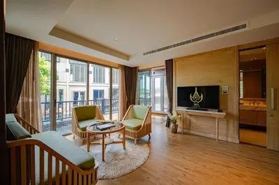 a living room with a couch and chairs and a tv at W1Bangkoknoi Hotel in Nonthaburi