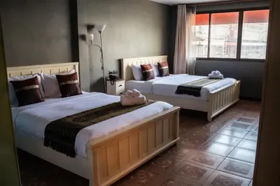 a bedroom with two beds and a window at Anandpura Riverside Hotel in Bangkok