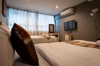 a bedroom with two beds and a flat screen tv at Anandpura Riverside Hotel in Bangkok