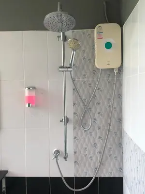 a shower with a shower head in a bathroom at Anandpura Riverside Hotel in Bangkok
