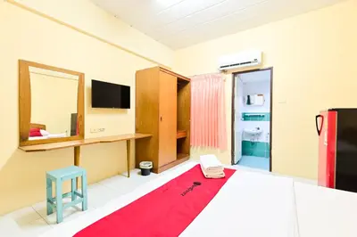 a bedroom with a bed and a mirror and a television at Big Bird Palace Ladprao 71 in Bangkok