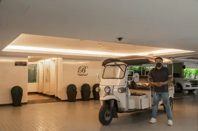 a man is standing next to a golf cart at Beverly 33 by Aspira in Bangkok