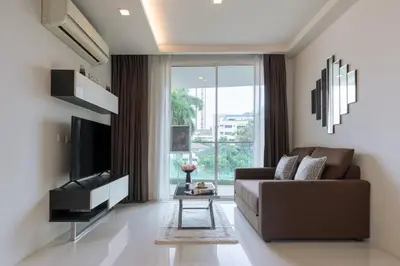 a living room with a couch and a television at Beverly 33 by Aspira in Bangkok