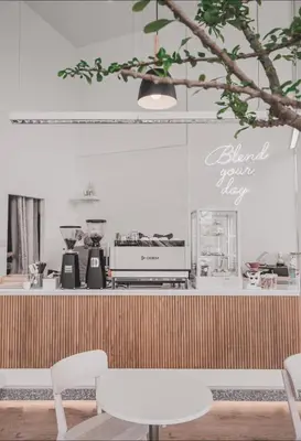 a counter with two white chairs in a room at Mintel Huamark in Bangkok