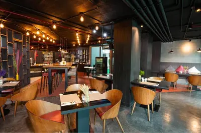 a restaurant with tables and chairs and a bar at RakYim Siam - Sukhumvit 15 in Bangkok