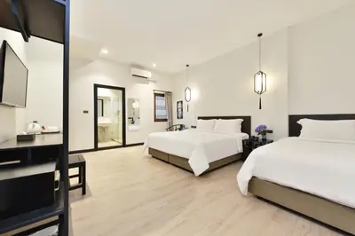 a bedroom with two beds and a flat screen tv at Oldthaiheng Hotel in Bangkok