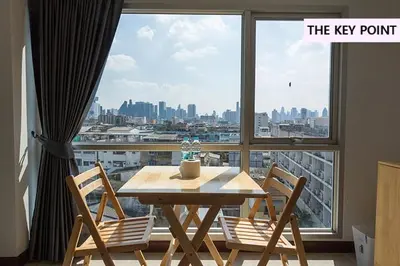 a table and chairs in a room with a large window at The Key Point Hotel in Bangkok