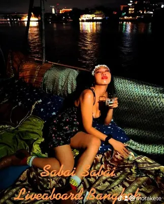 a woman sitting on the deck of a boat at Sabai Sabai Liveaboard Bangkok in Bangkok