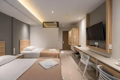 a hotel room with two beds and a flat screen tv at Haven 35 in Bangkok