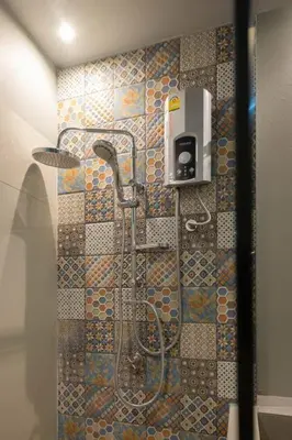 a bathroom with a shower with a tile wall at Haven 35 in Bangkok