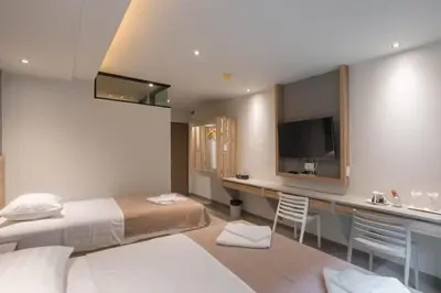 a bedroom with a bed and a desk with a television at Haven 35 in Bangkok