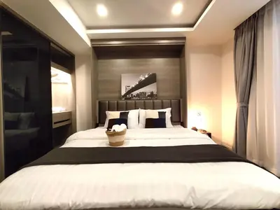 a bedroom with a large bed with a black headboard at Circle Rein Sukhumvit 12 #1BR#Pool&Gym#Near Terminal 21#Max2 in Bangkok